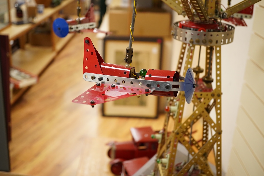 A Meccano model of a fairground ride, incorporating an electric motor in the base and lighting throughout, built in the style of a shop display centrepiece, approx 106cm high, 85cm diameter